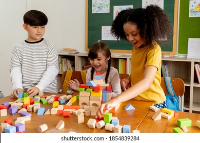 Group Of Multiethnic School Friends Using Toy Blocks In Classroom, Education, Learning, Teamwork. Children Playing With Wooden Blocks In Classroom