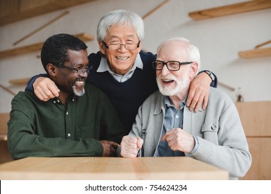 Group Of Multiethnic Senior Friends Embracing In Bar