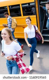 Group Of Multiethnic Teen Scholars Running Out School Bus 