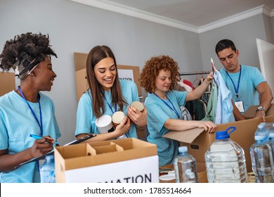 Group of multiethnic volunteers putting food and drinks into paper box for charity. Group of people working in charitable foundation. Happy volunteer looking at donation box on a sunny day. - Shutterstock ID 1785514664