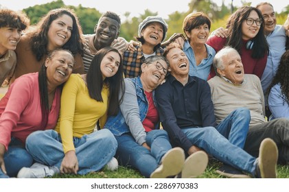 Group of multigenerational people having fun together outdoor - Multiracial friends enjoy day at city park - Powered by Shutterstock