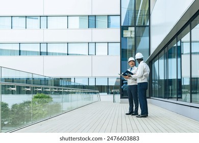 A group of multinational engineers having a conversation in front of a building - Powered by Shutterstock