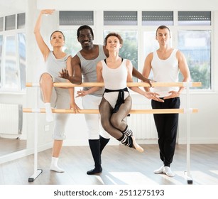 Group of multinational male and female dancers posing at ballet barre in dance studio - Powered by Shutterstock