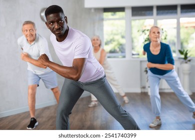 Group of multinational sports aged people rehearsing hip hop dance in dance hall - Powered by Shutterstock