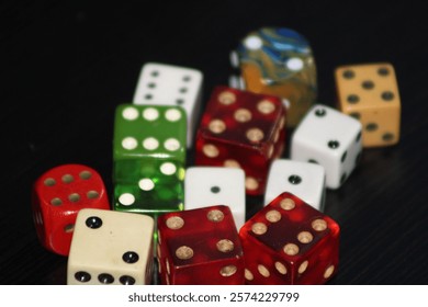 A Group Of Multiple Colored Dice Laying On A Table With A Black Background. 