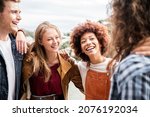 Group of multiracial best friends laughing together outdoor - Mixed race students having fun at college campus -  Friendship, tourism, community, youth and university concept.	