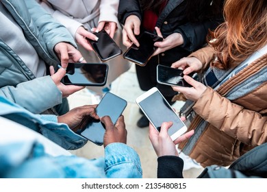 Group Of Multiracial Friends Addicted To Mobile Phones To Share On Social Media Network And Stay In Touch - Close Up On Hands Holding Smartphone, Friendship And Technology Concepts