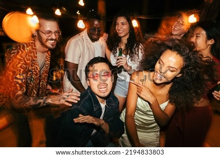 A group of multiracial friends is dancing at the nightclub. They have a great time at the open-air club. Stock photo © 