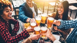 Group Of Multiracial Friends Having Bbq Dinner Party Together - Diverse Young People Sitting At Bar Table Toasting Beer Glasses In Brewery Pub Garden - Brewery, Dining Lifestyle And Food Concept
