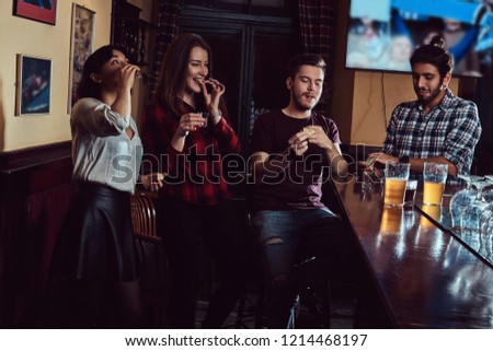 Group of multiracial friends resting and talking at the bar or pub.