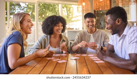 Group Of Multi-Racial Friends Sitting Around Table Playing Game Of Cards At Home Together - Powered by Shutterstock