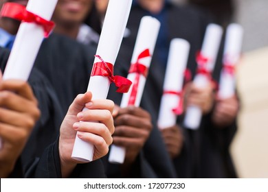 group of multiracial graduates holding diploma