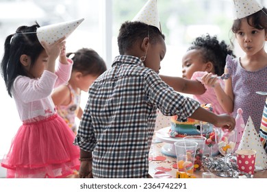 Group of multiracial little boy and girls enjoy eating beautiful rainbow cakes and candy in party - Shutterstock ID 2364742291