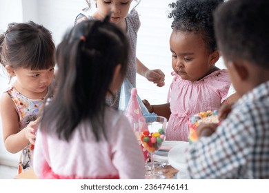 Group of multiracial little boy and girls enjoy eating beautiful rainbow cakes and candy in party, having fun in party room - Shutterstock ID 2364746141