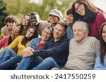 Group of multiracial people with different ages having fun together at city park - Community and social gathering concept