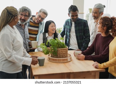 Group of multiracial people drinking coffee together indoor - Multi generational friends concept - Powered by Shutterstock