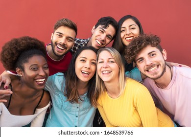 Group multiracial people having fun outdoor - Happy mixed race friends sharing time together - Youth millennial generation and multiethnic teenagers lifestyle concept - Red Background - Powered by Shutterstock