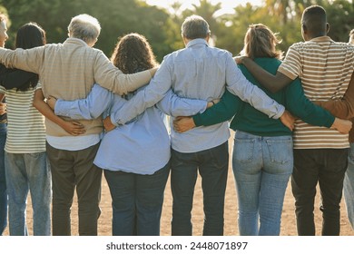 Group of multiracial people hugging each other at city park - Back view of multi generational community outdoor - Powered by Shutterstock