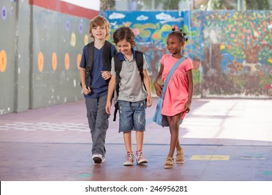Group of multiracial schoolmates walking and smiling.