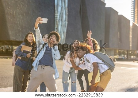 Group of multiracial students taking a selfie and leaving the university campus. Focus on the Indian boy