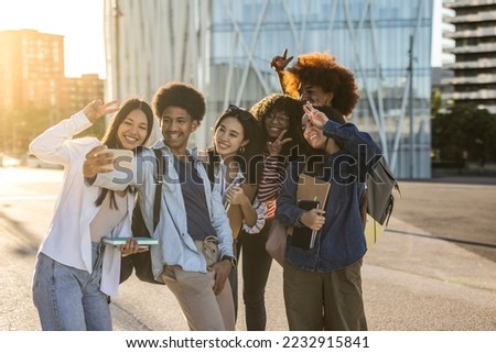 Group of multiracial students taking a selfie and making peace symbol with hands in the university campus. Focus on african american boy