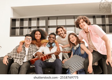 A group of multiracial teenagers playing guitar and singing a song together at an afternoon party. A group of Millennials sitting and spending time together on the holiday weekend.
 - Powered by Shutterstock