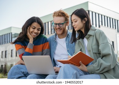 Group of multiracial university students using laptop, studying, exam preparation, education concept. Young smiling colleagues meeting, cooperation, planning project, working together outdoors 