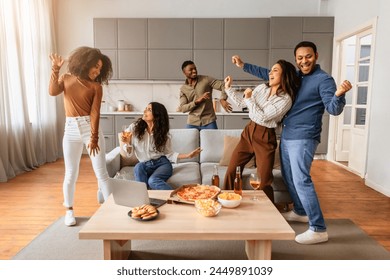 A group of multiracial, young people are seen dancing and having fun together at a friends gathering at home - Powered by Shutterstock