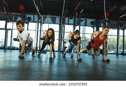 A Group Of Muscular Athletes Doing Workout At The Gym. Gymnastics, Training, Fitness Workout Flexibility. Active And Healthy Lifestyle, Youth, Bodybuilding. Training In Exercises With Weights.