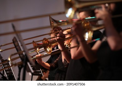 Grupo de músicos de jazz tocando varios instrumentos musicales trompeta trombona saxofónica dorada en el escenario consecutivo