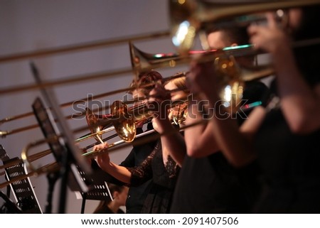 Group of musicians jazz band playing various musical instruments golden saxophone trombone trumpet standing on stage in a row