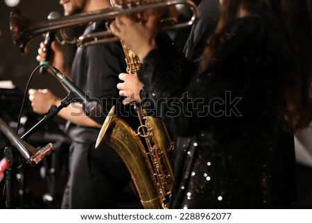A group of musicians playing with a focus on the microphone.Background image