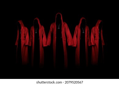 Group of mystery people in a red hooded cloaks.  Unrecognizable person. Hiding face in shadow. Ghostly figure. Satanic sect member. Conspiracy concept. Isolated on black. - Shutterstock ID 2079520567