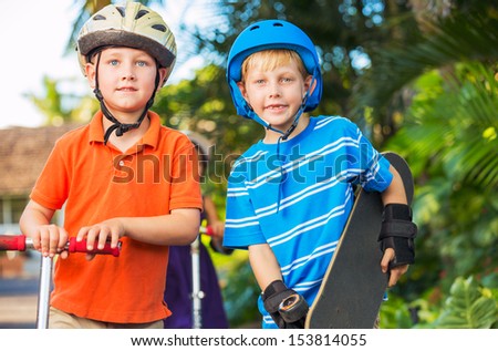 Group of Neighborhood Kids with Skateboards and Scooters Playing