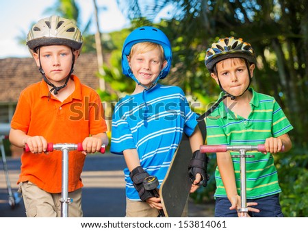Group of Neighborhood Kids with Skateboards and Scooters Playing
