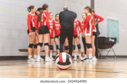 A group of nice teen sport in gymnase play volleyball, focus on ball in front - Powered by Shutterstock