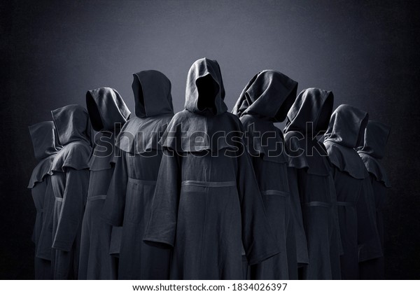 Group of nine scary figures in hooded cloaks in the dark