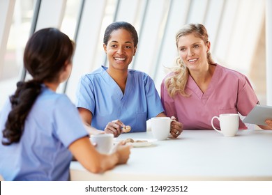 Group Of Nurses Chatting In Modern Hospital Canteen