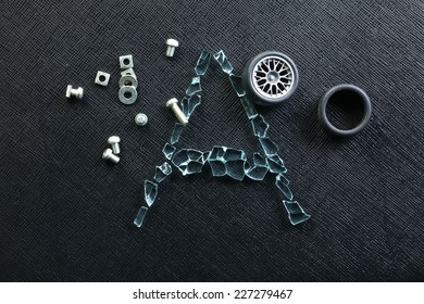 A group of nuts put beside plastic model of aluminum alloy wheel among broken tempered glass represent the damaged abstract meaning - Shutterstock ID 227279467