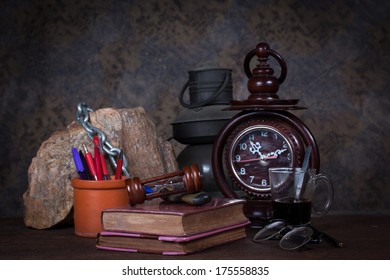 Group of objects on wood table. old clock, old books, rock ,glasses, pencil, pen, old rusty kerosene lamp, glass of coffee, Still life
