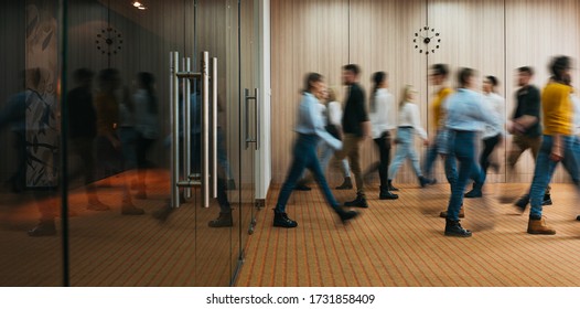 Group Of Office Employees In Motion Go Around At Coworking Space. People In Business Center Walking  At Hall. Motion Blur. Wide Image