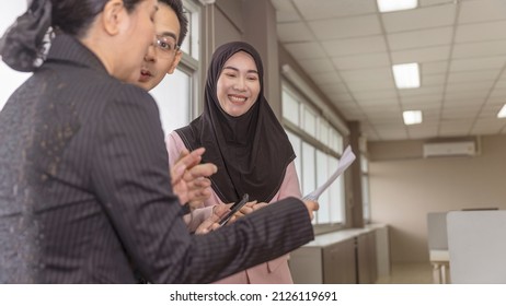 A group of office workers from different religious exchange ideas during discussion in an office. Group discussion with cultural diversity. Gender equality in a business office.