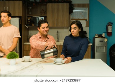 Group of office workers enjoying a cup of coffee together in a break room - Powered by Shutterstock