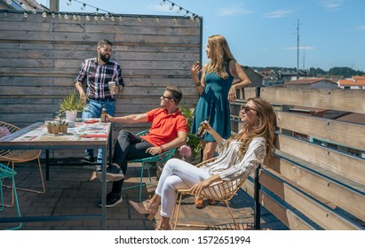 Group of office workers talking and drinking on the terrace during the break
