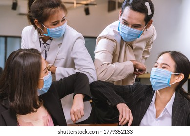 Group Of Officer Wearing Face Mask For Prevent Covid19. Have New Normal Greeting By Elbow Bump.