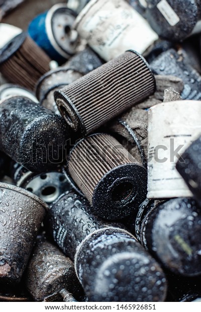 group of old car oil filters and leaked oil at\
shallow depth of field