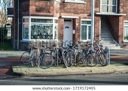 Group of a lot of old holland vintage classic bicycles row parked at parking station in public. Cityscape view. Dutch lifestyle
