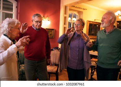 Group Of Old People Smiling And Dancing Together At Nursing Home