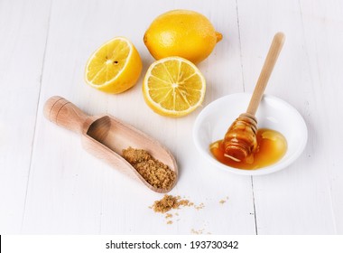 Group Of Organic Lemons With Honey And Brown Sugar Over White Wooden Background 