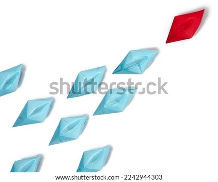 Group of paper boats on a white background.Concept of a strong leader in a team, manipulation of the masses, following new perspectives, collaboration and unification.